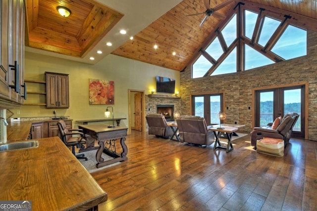 living area with wood ceiling, a fireplace, dark wood finished floors, and french doors