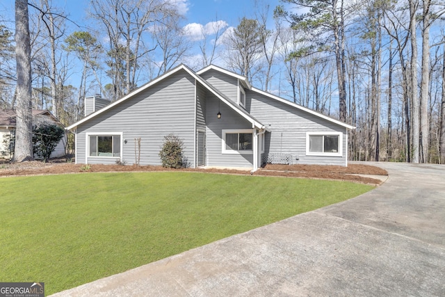 view of front of home featuring a chimney and a front lawn