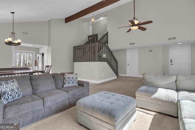 carpeted living room with visible vents, beamed ceiling, and stairway