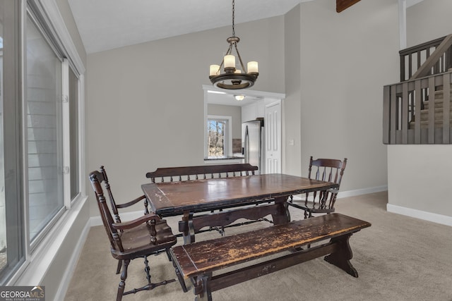 dining room with baseboards, stairway, light colored carpet, vaulted ceiling, and a notable chandelier