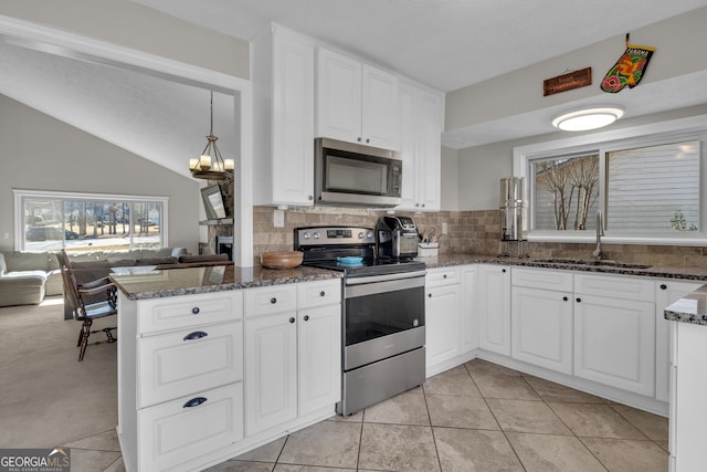 kitchen with open floor plan, appliances with stainless steel finishes, white cabinetry, and a sink