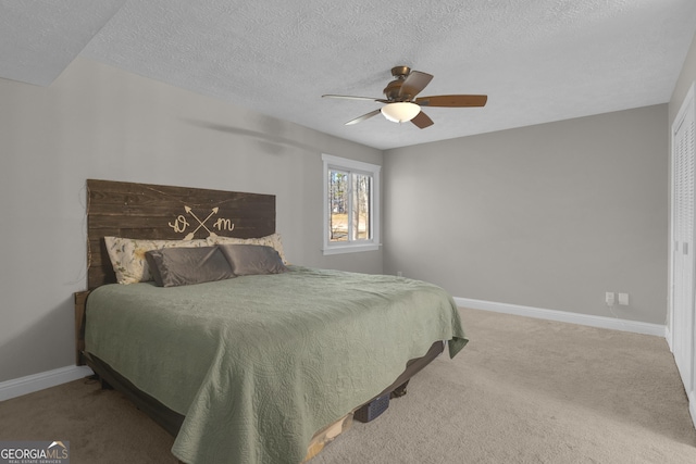 carpeted bedroom with baseboards, a textured ceiling, and ceiling fan