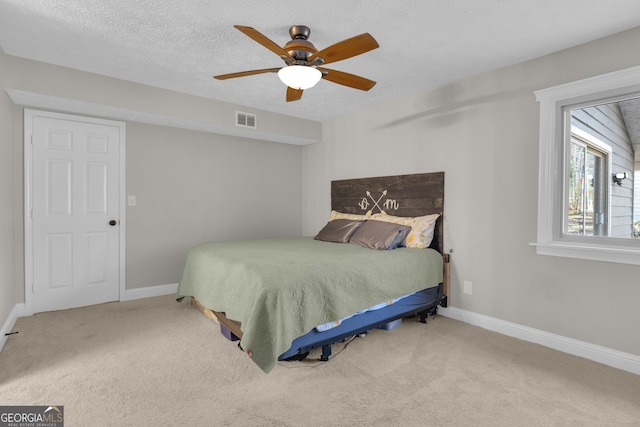 bedroom featuring baseboards, carpet, visible vents, and a textured ceiling