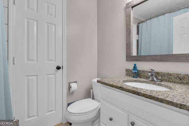 full bathroom with toilet, a textured ceiling, and vanity