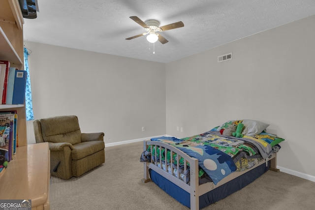 carpeted bedroom featuring visible vents, baseboards, a textured ceiling, and ceiling fan