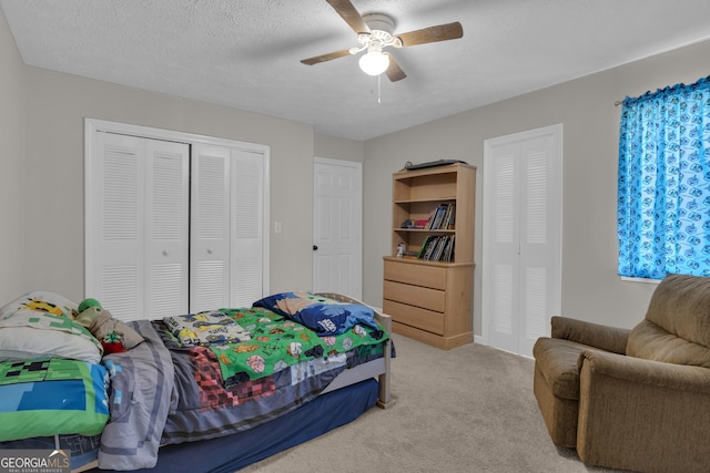 bedroom featuring a closet, carpet flooring, a textured ceiling, and a ceiling fan