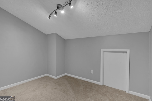 bonus room featuring carpet flooring, baseboards, and a textured ceiling