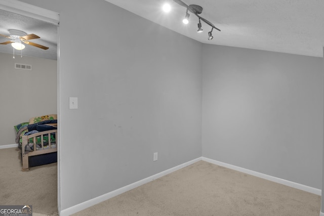 empty room with visible vents, a textured ceiling, baseboards, and carpet floors