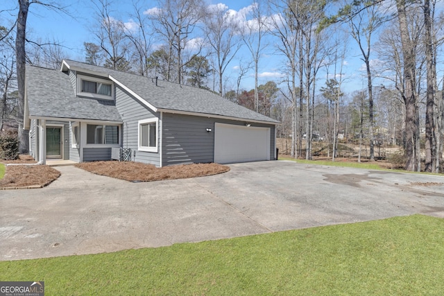 view of side of home with a garage, a yard, and roof with shingles