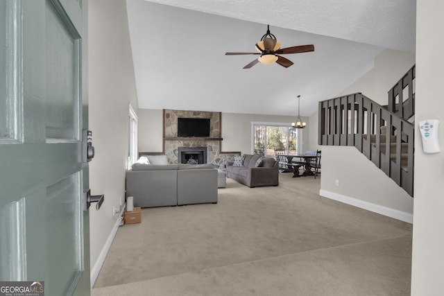 carpeted living room featuring a stone fireplace, ceiling fan with notable chandelier, stairs, and baseboards