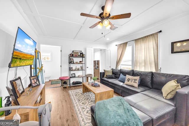 living area with visible vents, a ceiling fan, coffered ceiling, and wood finished floors