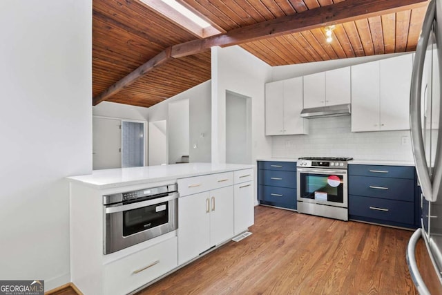 kitchen featuring stainless steel appliances, white cabinetry, and backsplash