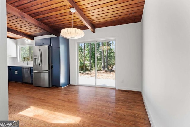 interior space with beamed ceiling, wooden ceiling, wood finished floors, and baseboards