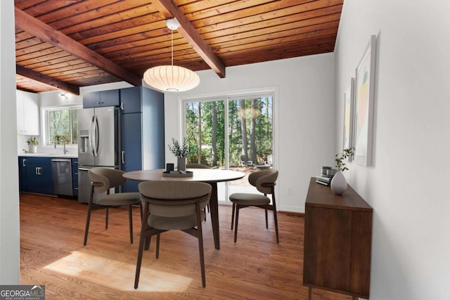 dining room with wooden ceiling, baseboards, beam ceiling, and wood finished floors