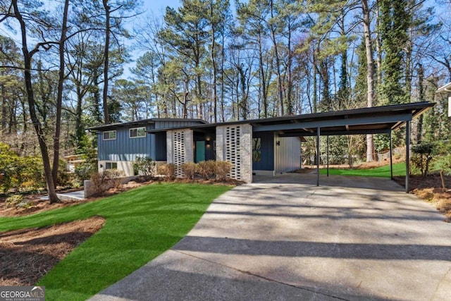 mid-century inspired home featuring driveway, board and batten siding, and a front yard