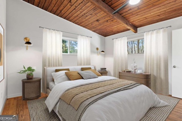 bedroom with vaulted ceiling with beams, wood ceiling, baseboards, and wood finished floors