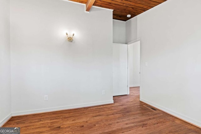 spare room with wooden ceiling, wood finished floors, visible vents, and baseboards