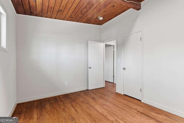 unfurnished bedroom with light wood-type flooring, wooden ceiling, and baseboards