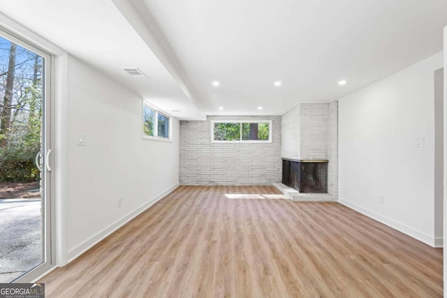 unfurnished living room featuring recessed lighting, a fireplace, visible vents, baseboards, and light wood-type flooring