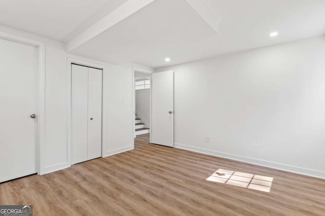 unfurnished bedroom featuring light wood finished floors, a closet, recessed lighting, and baseboards