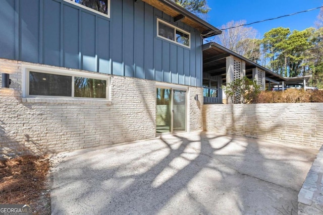 view of property exterior with board and batten siding and brick siding