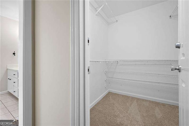 walk in closet featuring light tile patterned floors and light colored carpet
