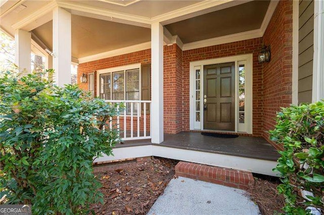 property entrance with covered porch and brick siding