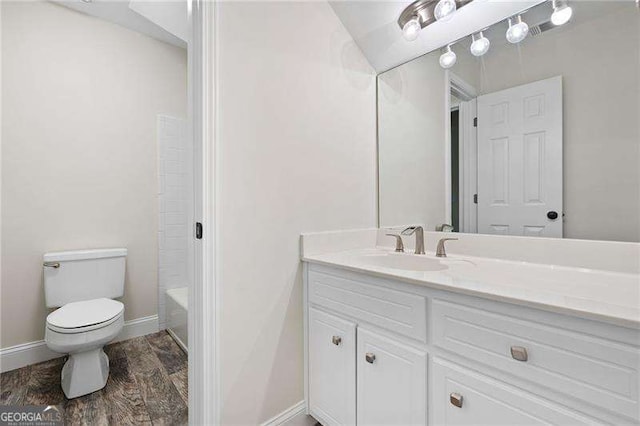 bathroom featuring wood finished floors, vanity, toilet, and baseboards