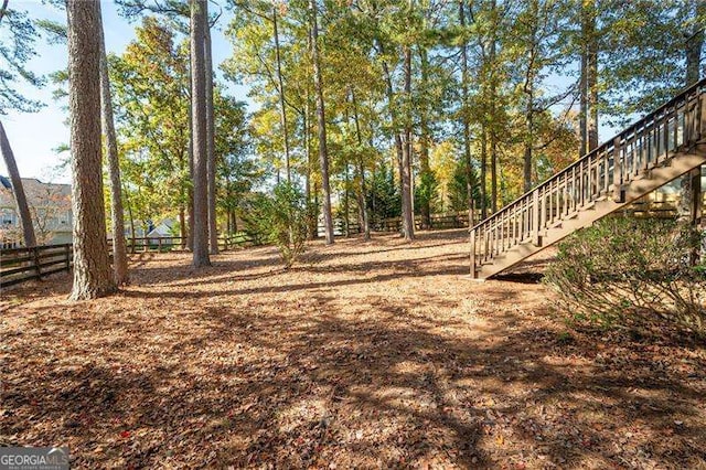 view of yard with fence and stairway