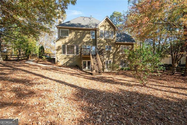 back of property with stairs, fence, and a deck