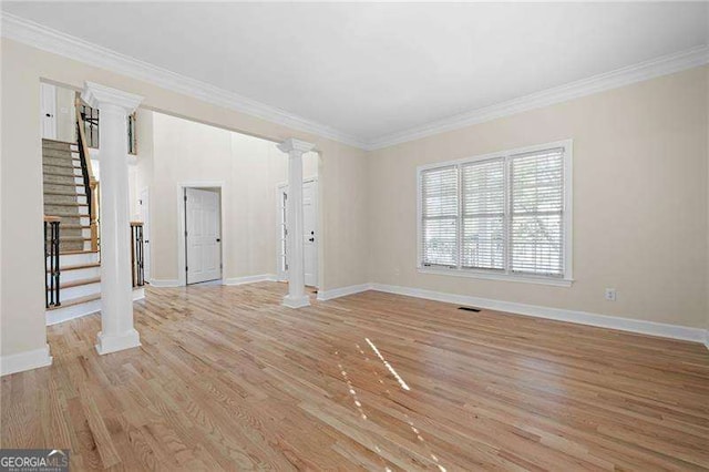 unfurnished living room with light wood-style floors, stairs, baseboards, ornamental molding, and ornate columns