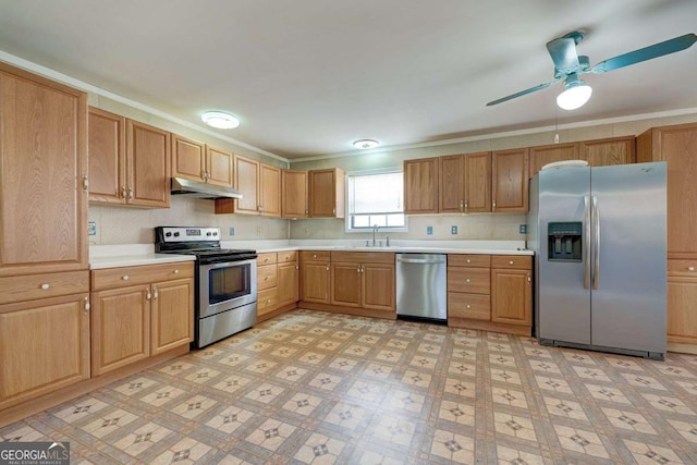 kitchen featuring light floors, light countertops, appliances with stainless steel finishes, a sink, and under cabinet range hood