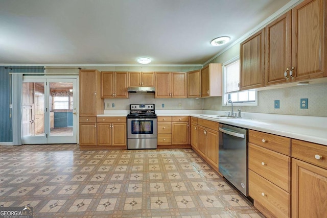 kitchen featuring light floors, stainless steel appliances, light countertops, a sink, and under cabinet range hood