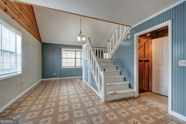 staircase with wallpapered walls, baseboards, lofted ceiling, tile patterned floors, and a notable chandelier