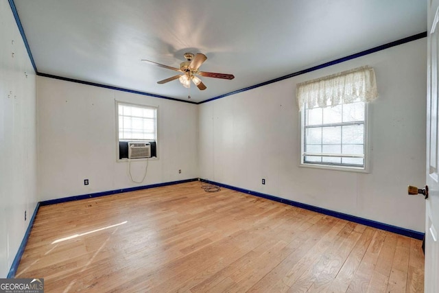 empty room featuring light wood finished floors, ceiling fan, ornamental molding, and baseboards