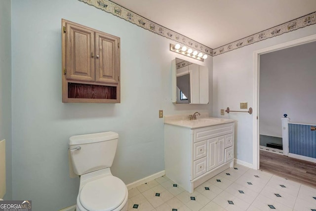 bathroom with tile patterned flooring, vanity, toilet, and baseboards