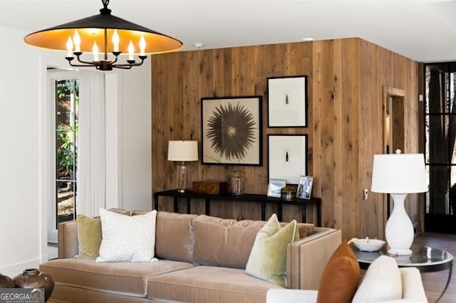 living room featuring a notable chandelier and wood walls