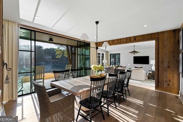 dining area featuring wooden walls and wood finished floors