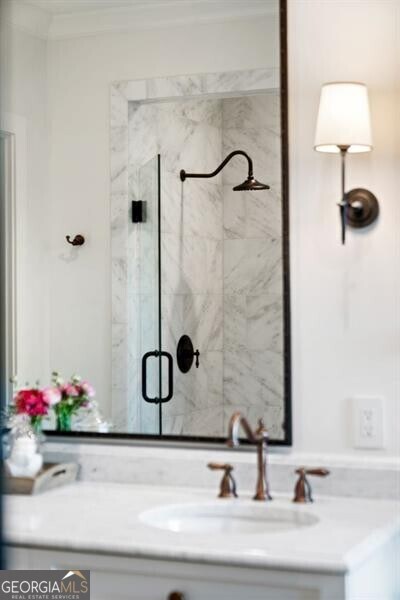 bathroom featuring vanity, crown molding, and a stall shower