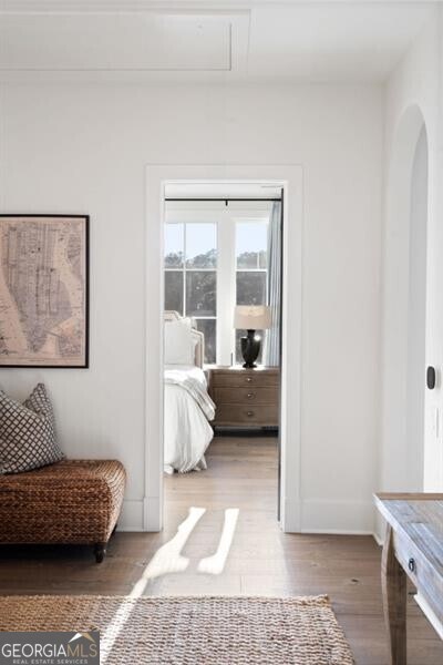 interior space featuring wood finished floors, arched walkways, and baseboards