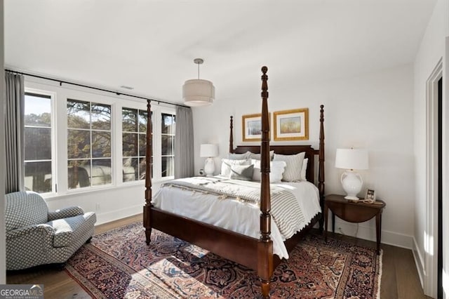 bedroom with baseboards and wood finished floors