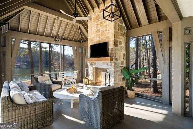 sunroom featuring a water view, an outdoor stone fireplace, wooden ceiling, and vaulted ceiling with beams