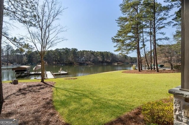 view of yard with a water view and a boat dock