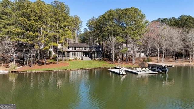 view of dock with a water view and a lawn