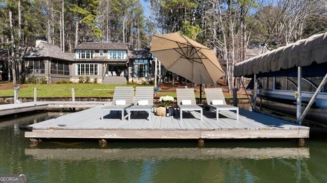 dock area with a lawn and a water view