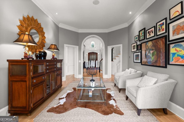 living room featuring stairs, light wood-style flooring, baseboards, and arched walkways