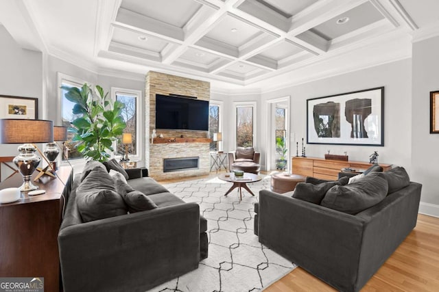 living room featuring a fireplace, light wood-style flooring, a healthy amount of sunlight, and coffered ceiling