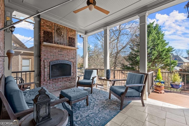 sunroom with a ceiling fan and an outdoor brick fireplace