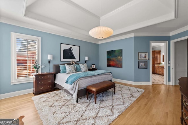 bedroom with a raised ceiling, baseboards, and wood finished floors