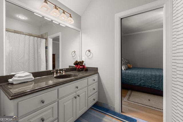 bathroom featuring vanity, ensuite bath, baseboards, and ornamental molding